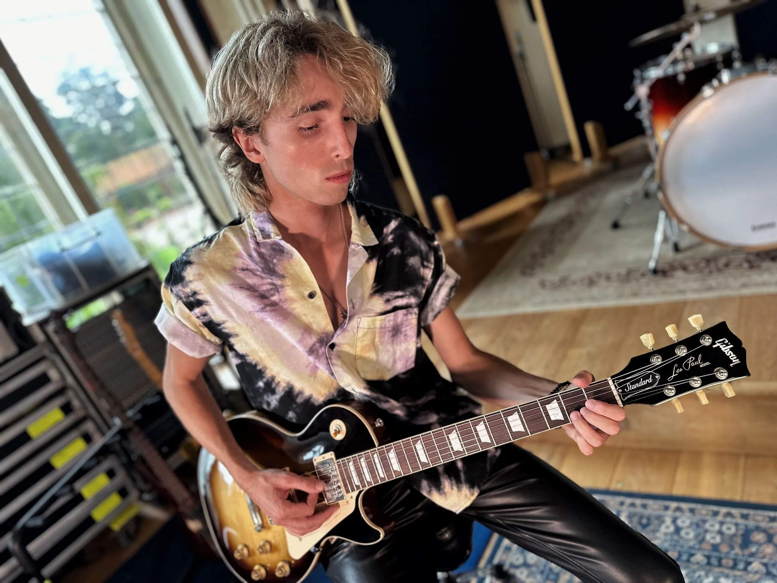 Sam Harding playing an electric guitar in a studio