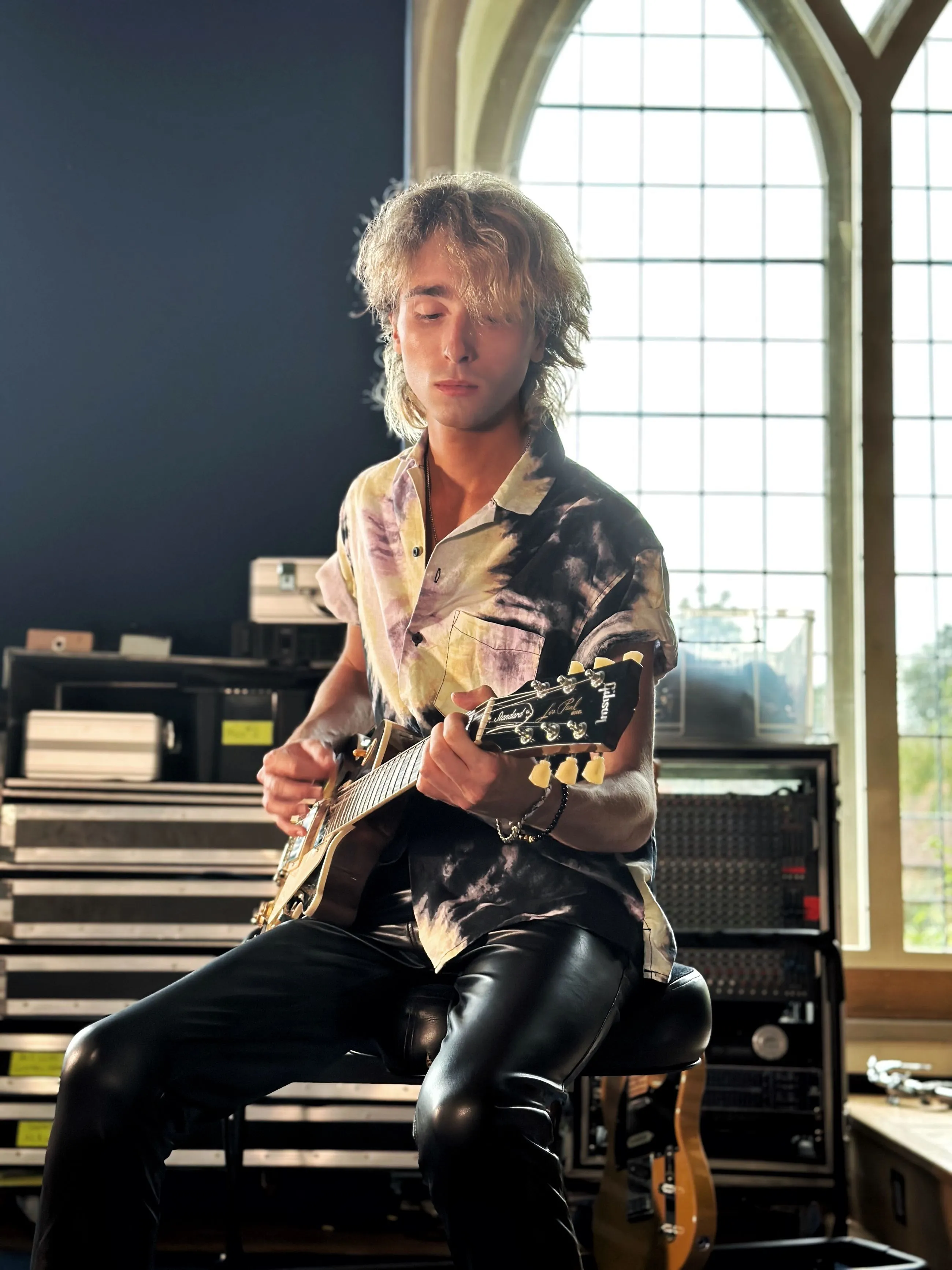 Sam Harding seated with an electric guitar