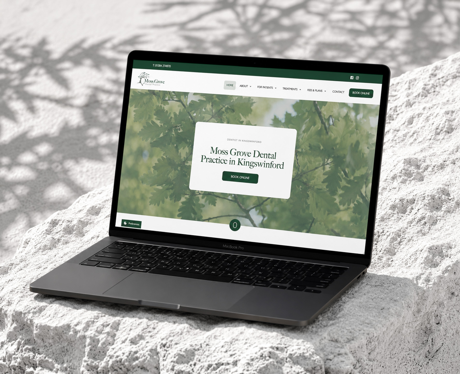 Moss Grove Dental Practice website displayed on a laptop on pale stone