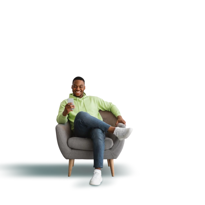 man sitting on couch looking at cellphone