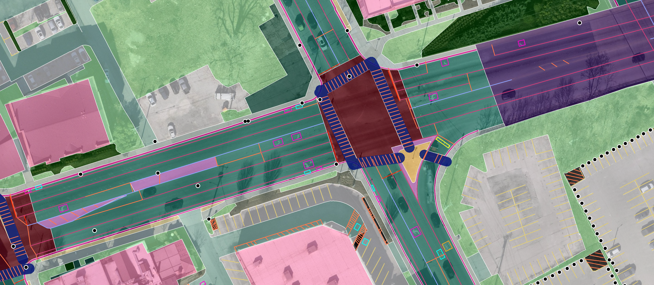 Ecopia vector map of a signalized intersection in Nashville, Tennessee: road segments, crosswalks, lane and stop lines, turn arrows, medians, turf, hedges, parking, and buildings drawn over aerial imagery