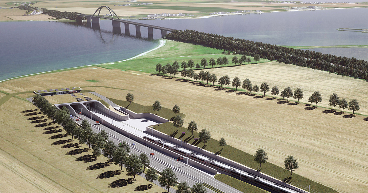 Luftaufnahme einer Brücke über Wasser mit Tunnel und Autobahn umgeben von Feldern und Bäumen.