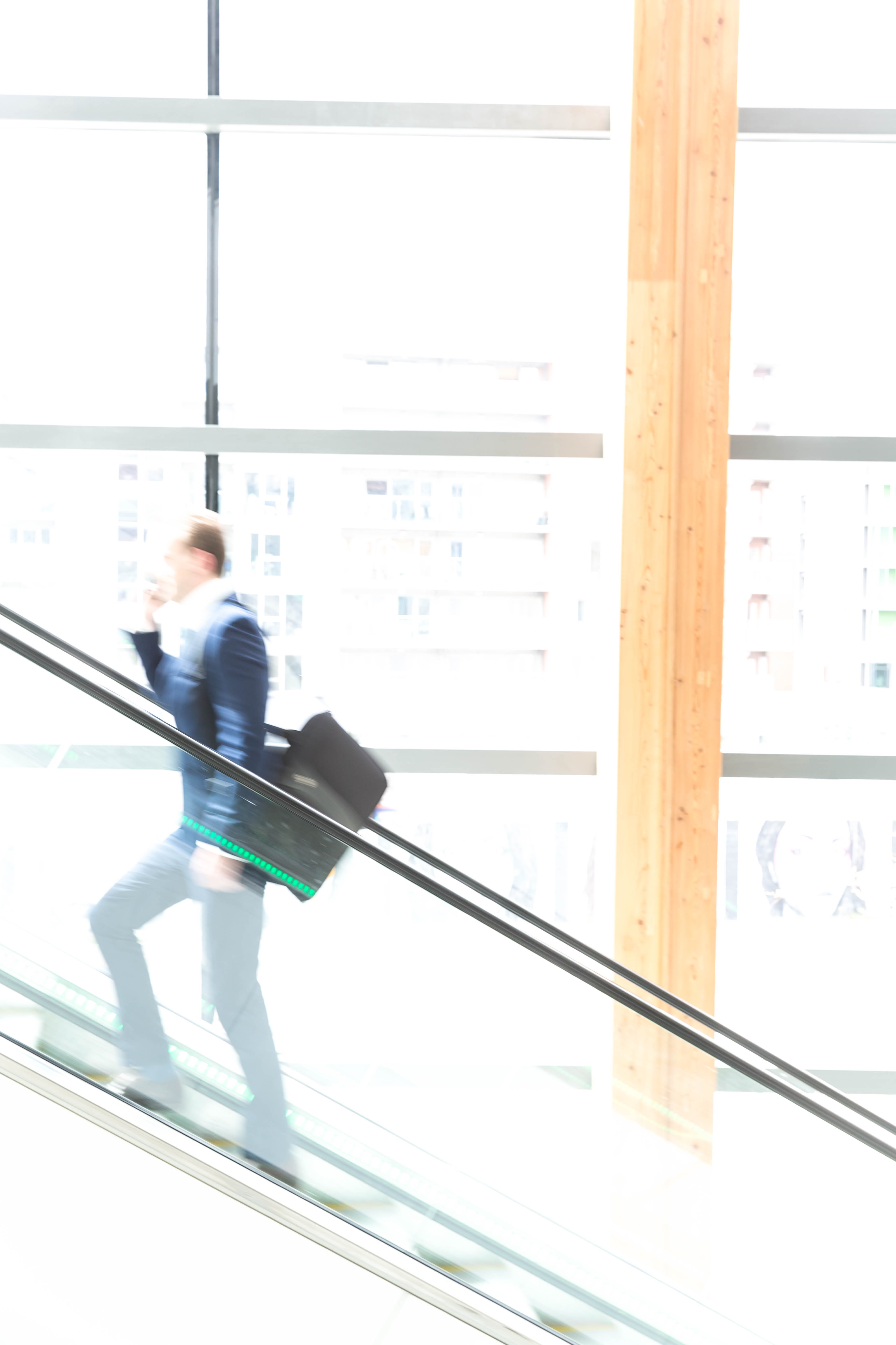 Corporate on Mobile With Laptop Bag on an Escalator - Corporate Photography © David Cantwell Photography