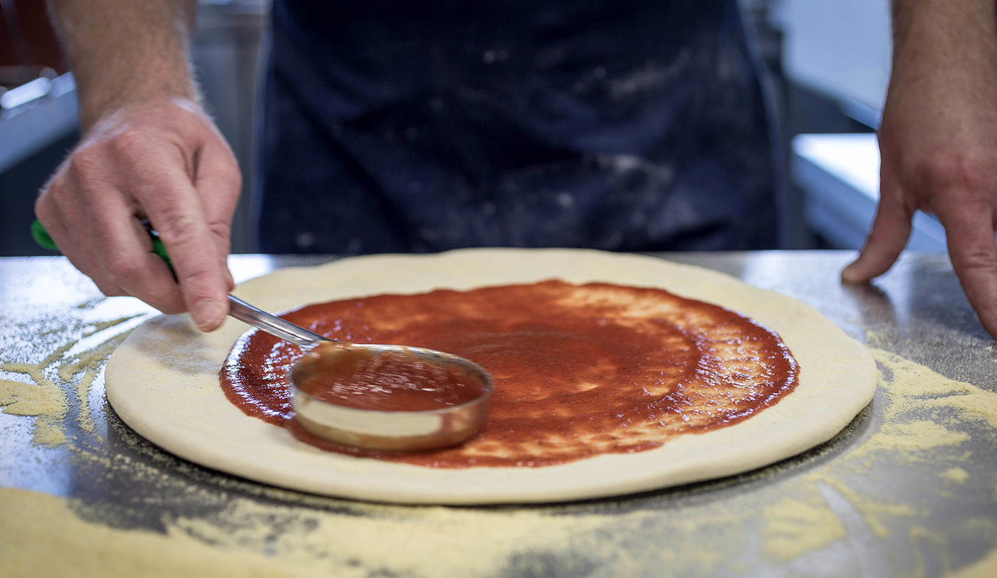 Chef Putting Sauce on Pizza Dough - Food Photography © David Cantwell Photography