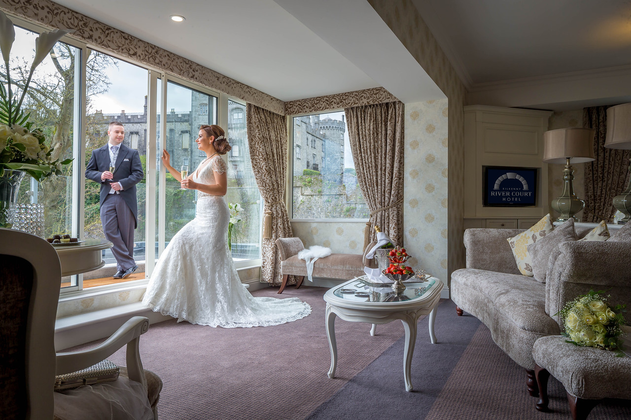 Bride & Groom at Kilkenny Rivercourt Hotel With Kilkenny Castle in Background - Hotel Lifestyle Photography © David Cantwell Photography