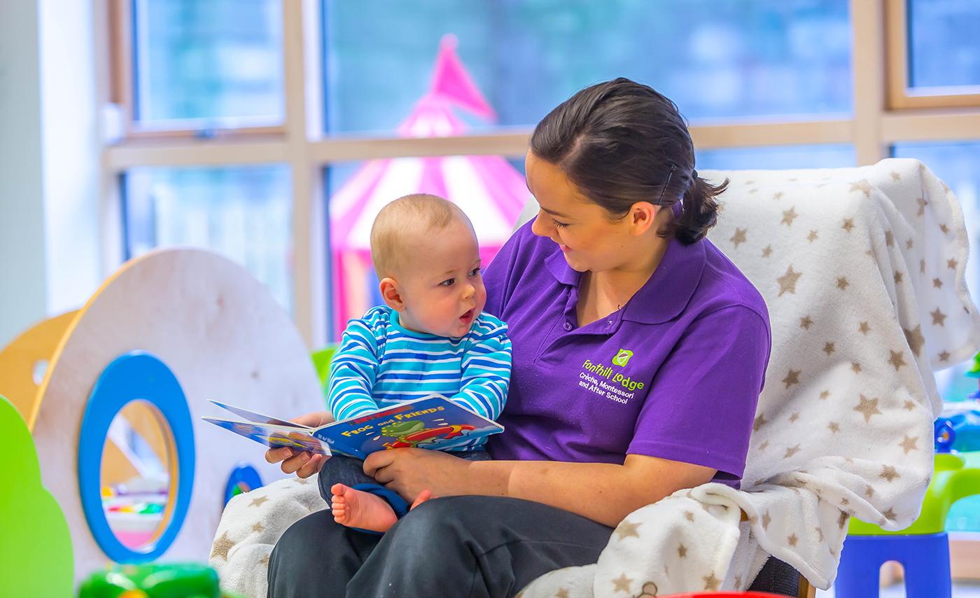 Fonthill Creche Staff Member Reading a Story to a Baby © David Cantwell Photography