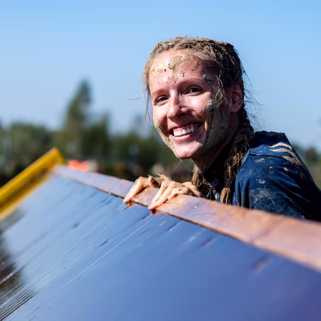 Participant on an obstacles with a muddy face