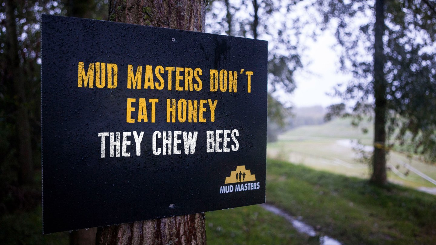 A sign that says: Mud Masters don't eat honey, they chew bees