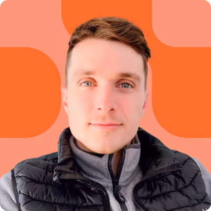 Young man with short light brown hair wearing a black puffer jacket, facing forward against an orange background.