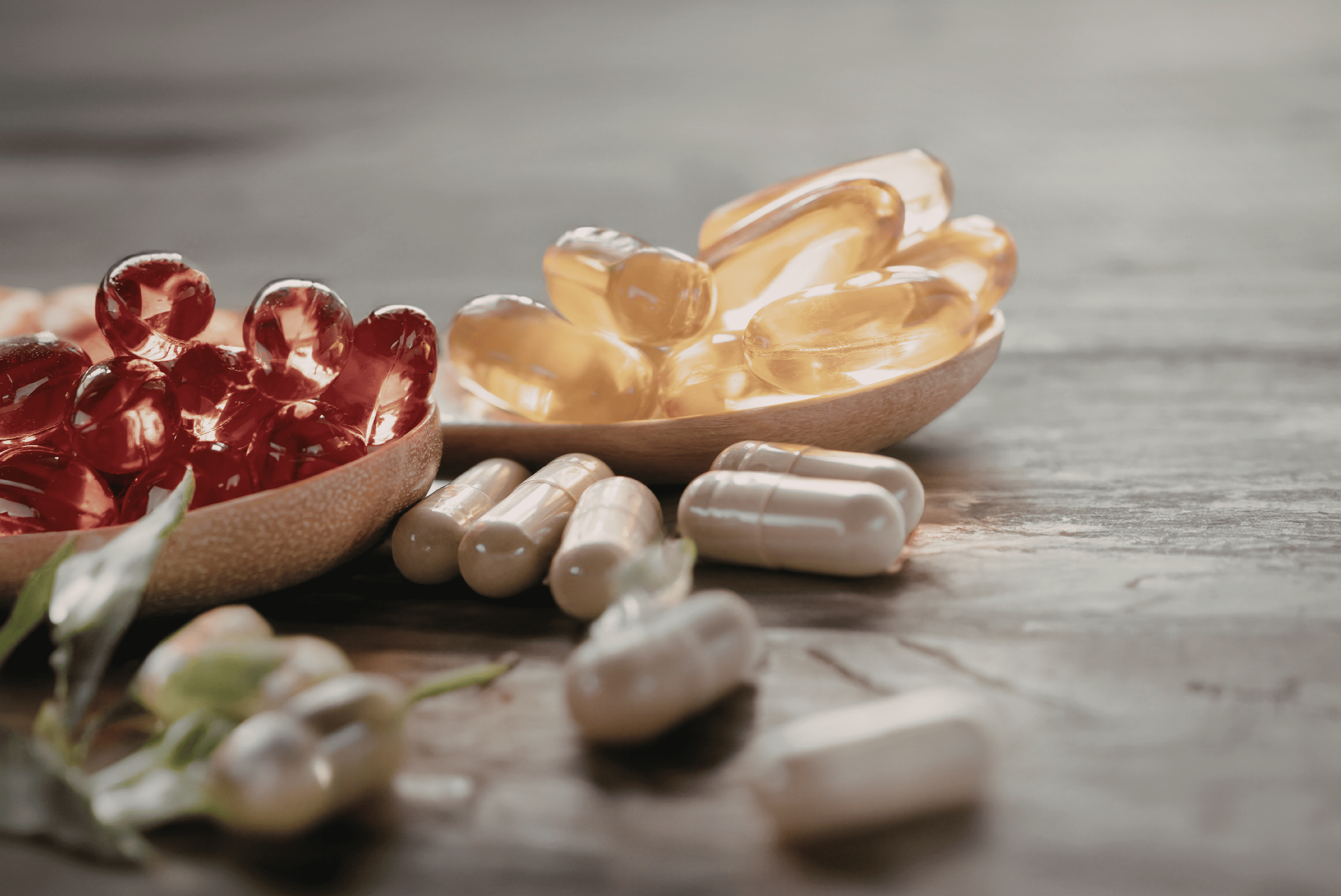 Compléments alimentaires en capsules et gélules sur une table, illustrant la nutrition, les vitamines et le bien-être.