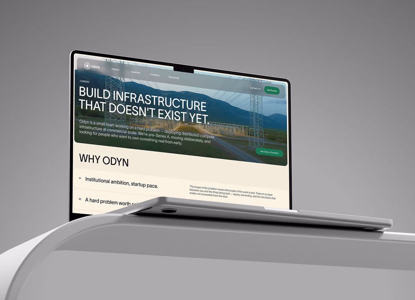 Laptop on white desk showing webpage about building infrastructure that doesn't exist yet by Odyn.
