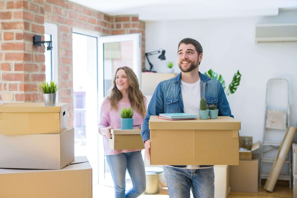 a man and woman moving into their new home with moving boxes