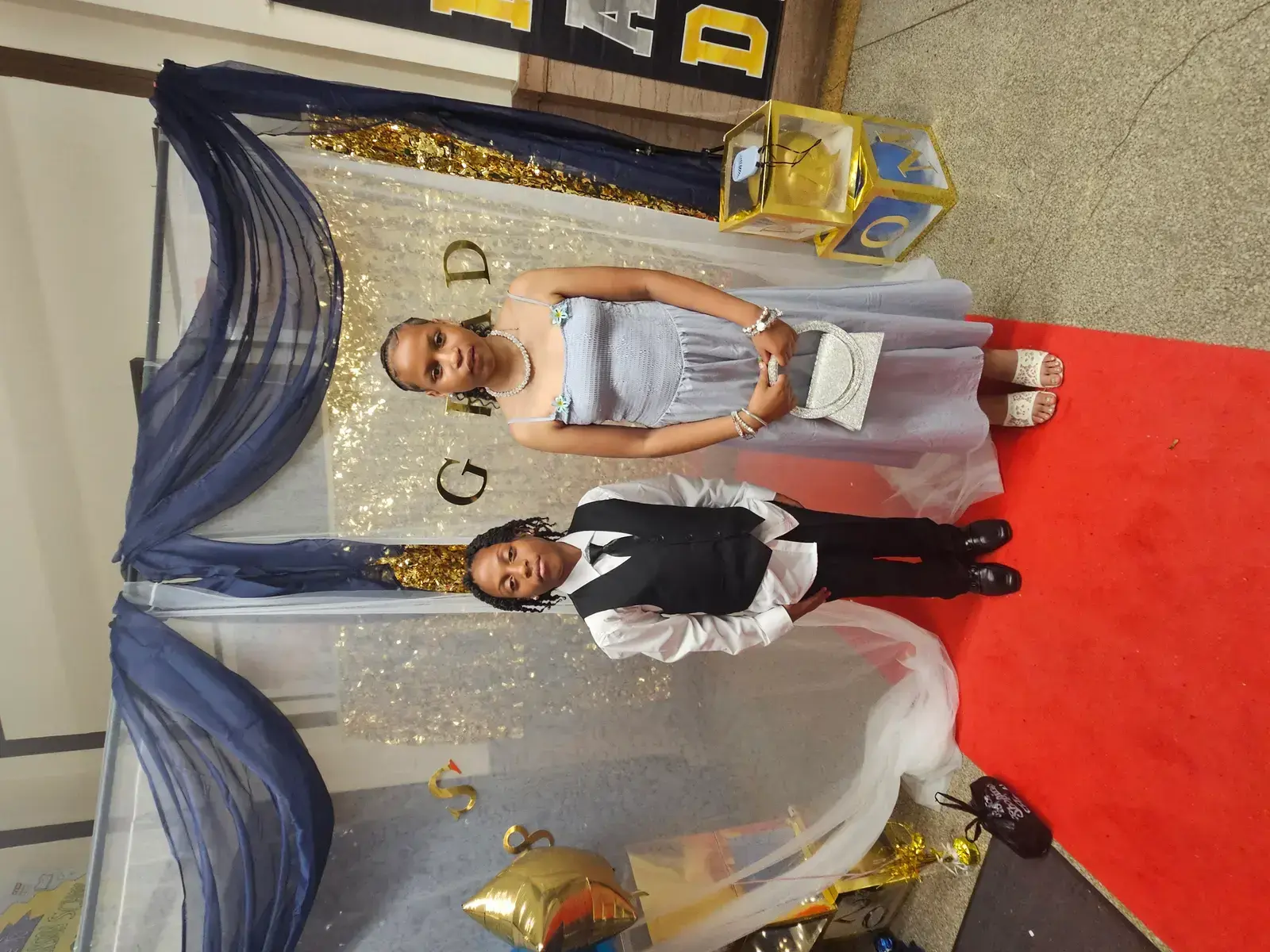Two students dressed formally posing at school prom event