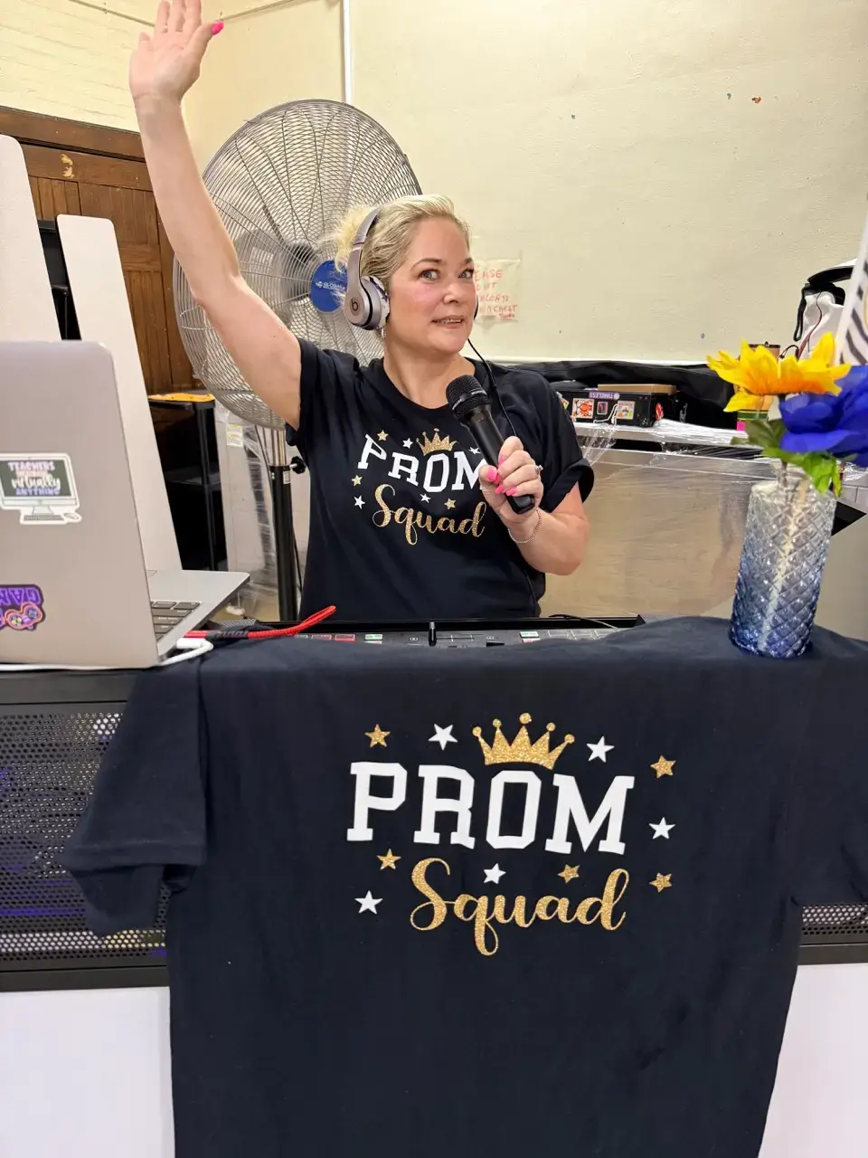 Prom Squad committee member speaking into microphone at event setup