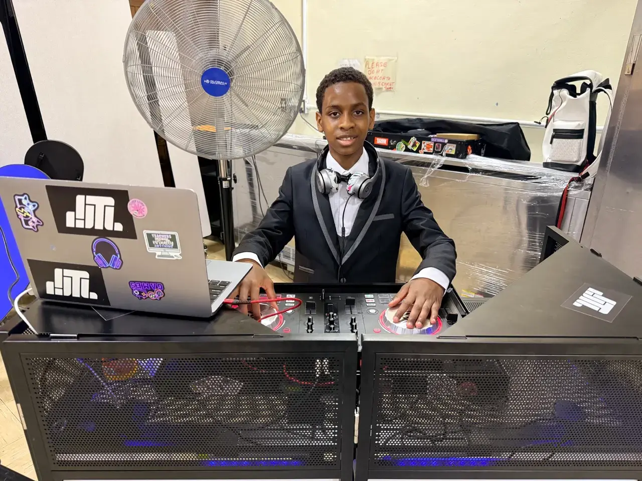 Student in formal suit DJing at school prom event