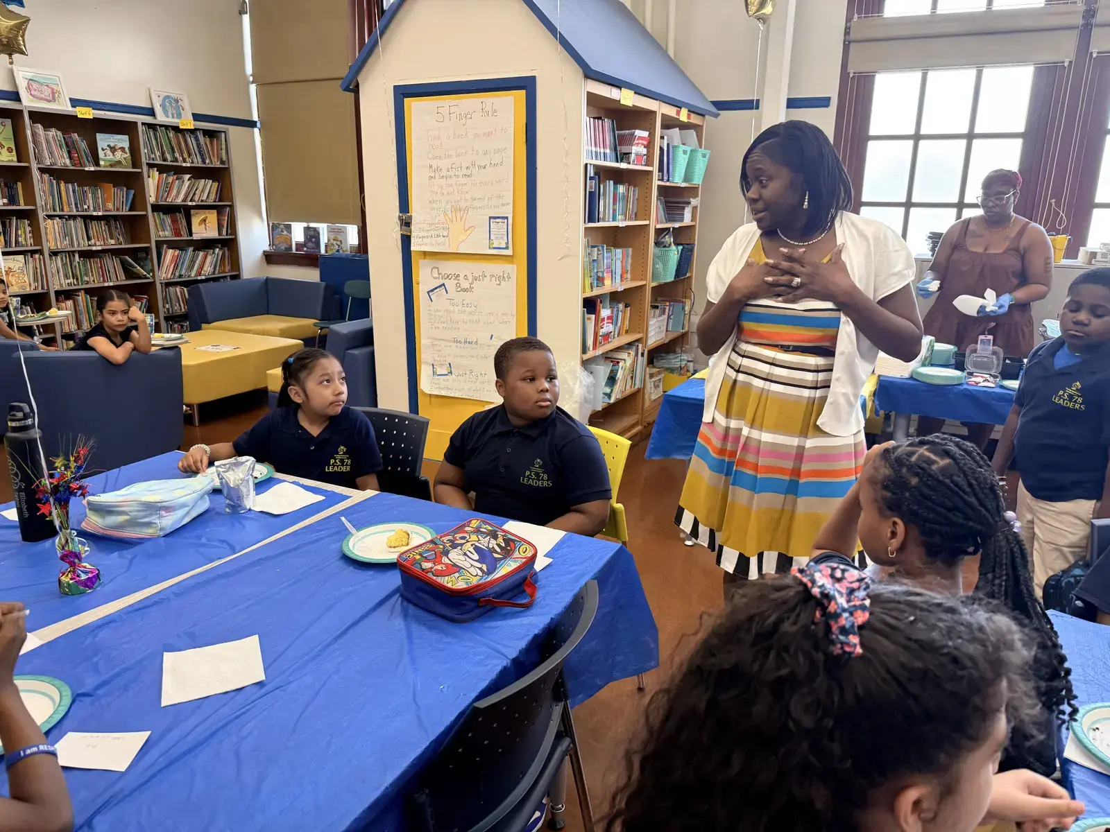 Principal addressing PS 78 students during a school library luncheon