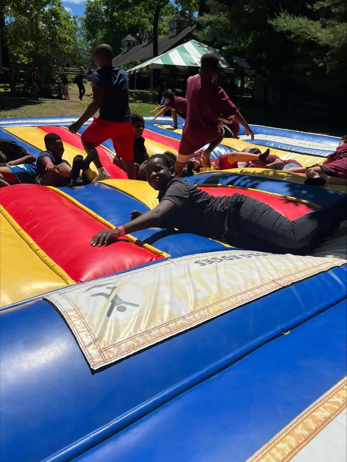 Students playing on a large colorful inflatable bounce pad outdoors