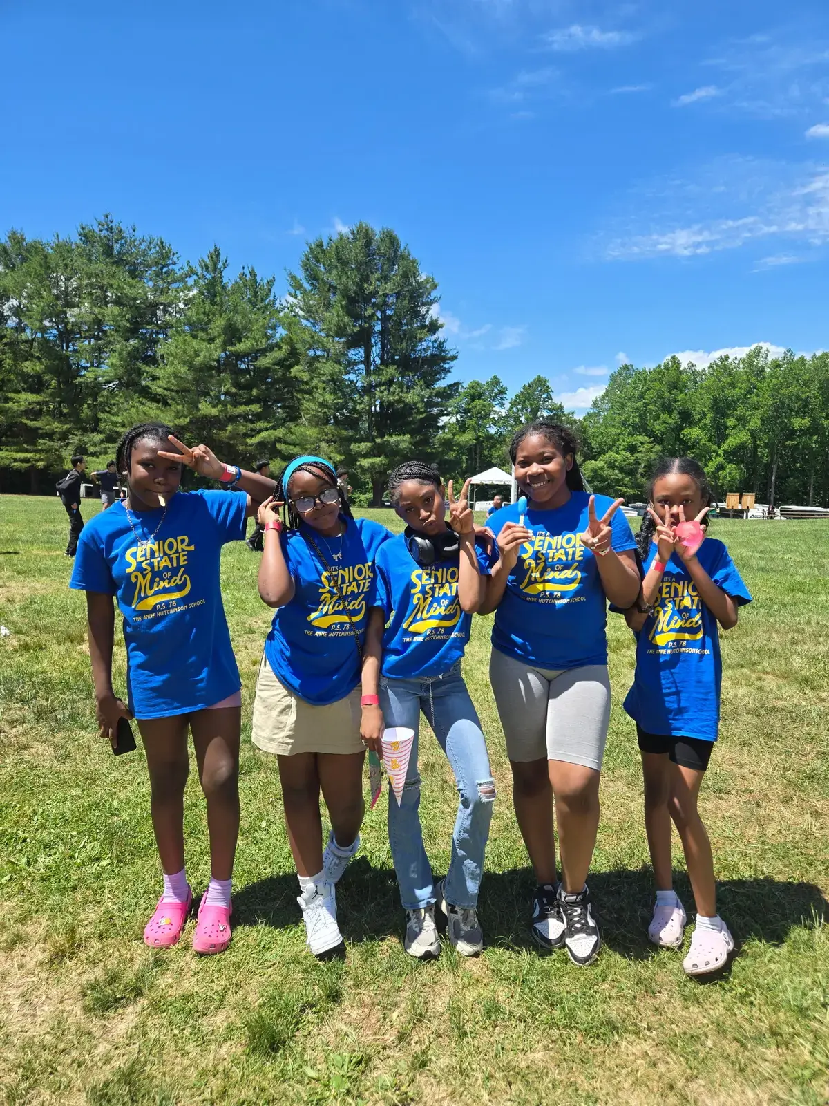 Five students in blue Senior State of Mind shirts posing outdoors