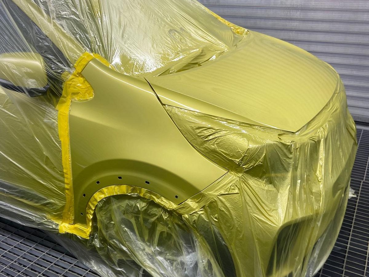 Technician applying colour in the spray booth at Stanways