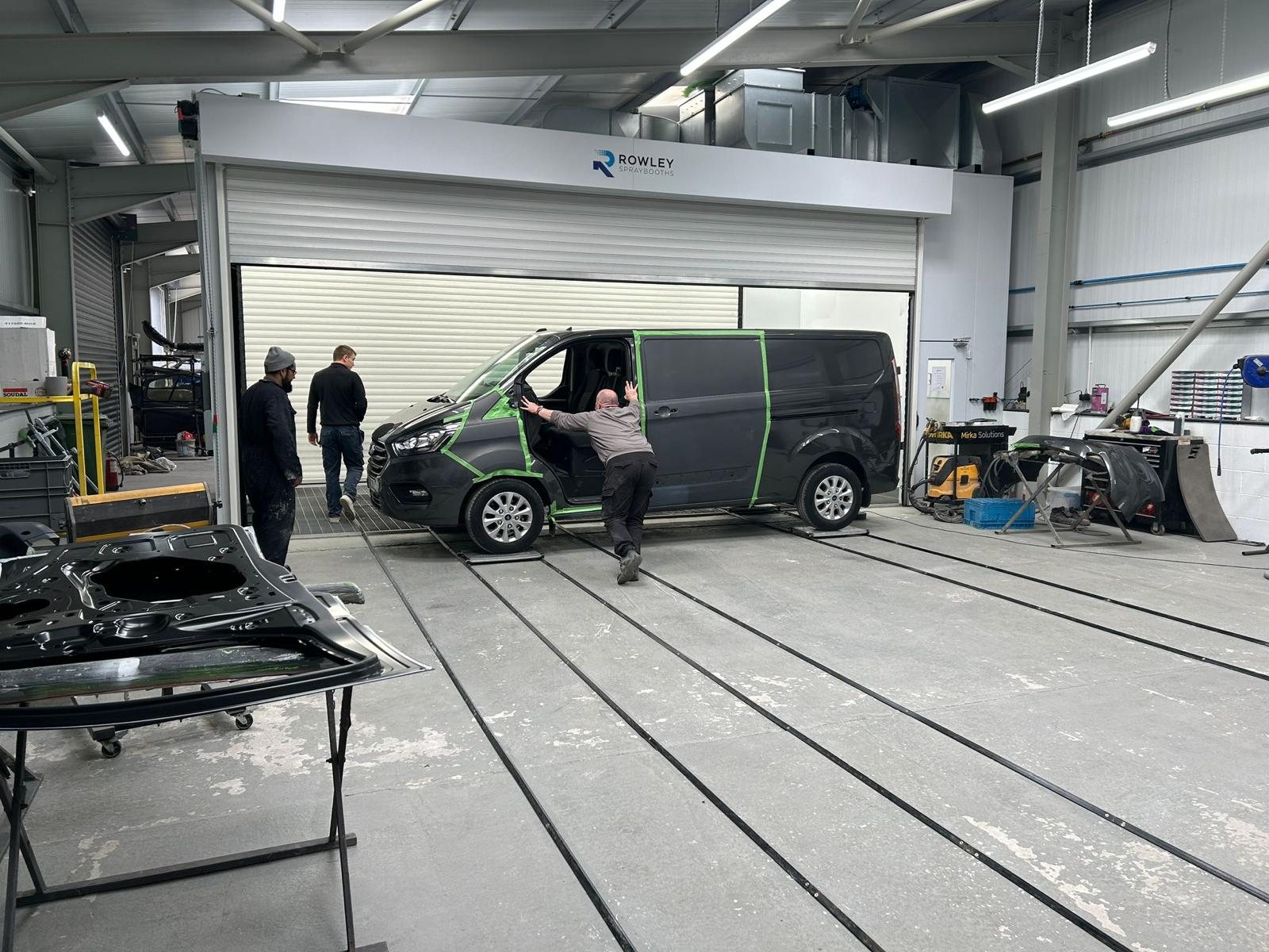 Vehicle being loaded into one of the twin Rowley spray booths