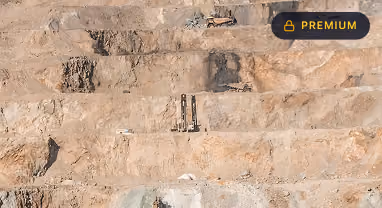 Terraced rocky hillside with mining equipment and a large excavator at the top level.