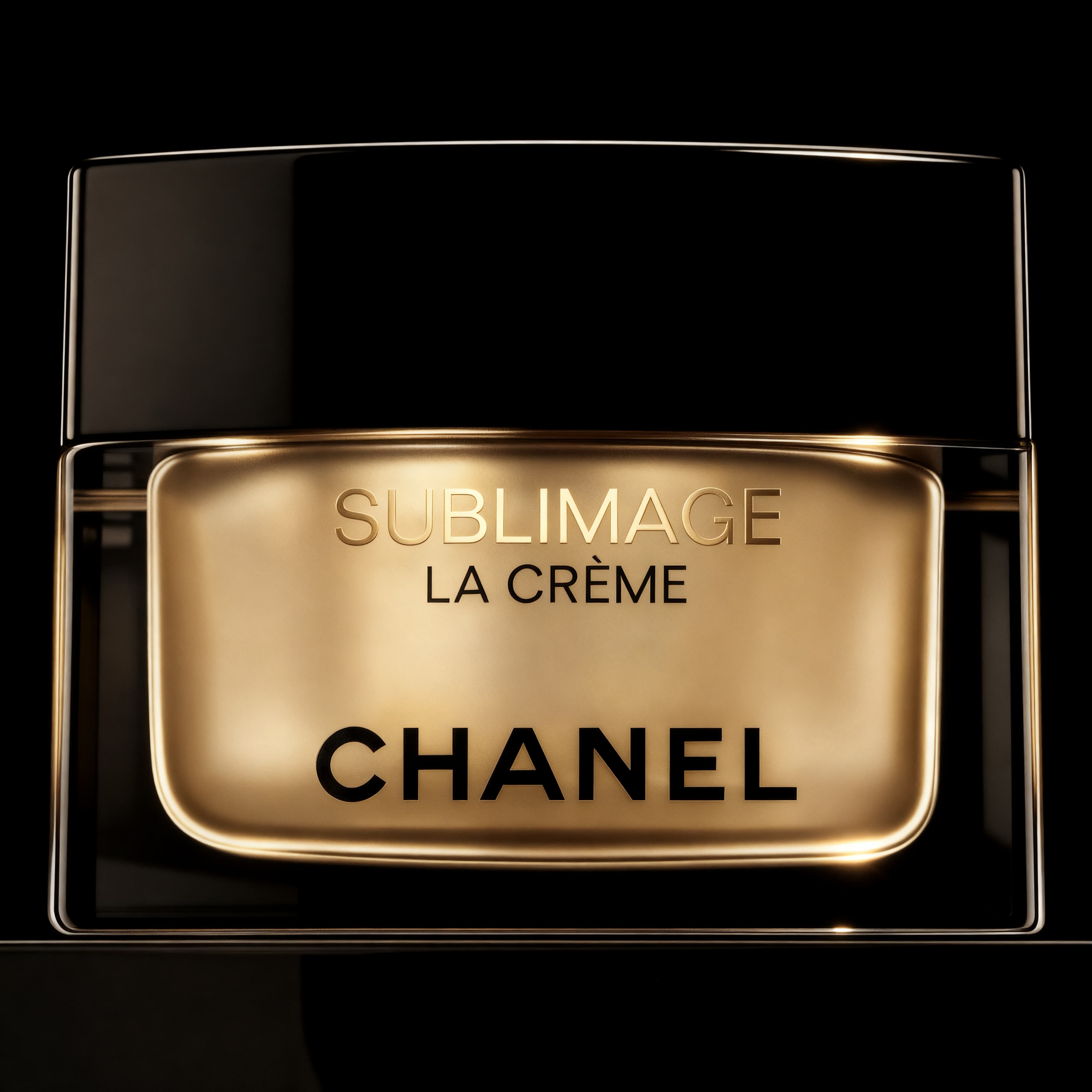 Luxury Chanel Sublimage La Crème skincare jar with golden and black packaging on a black background.