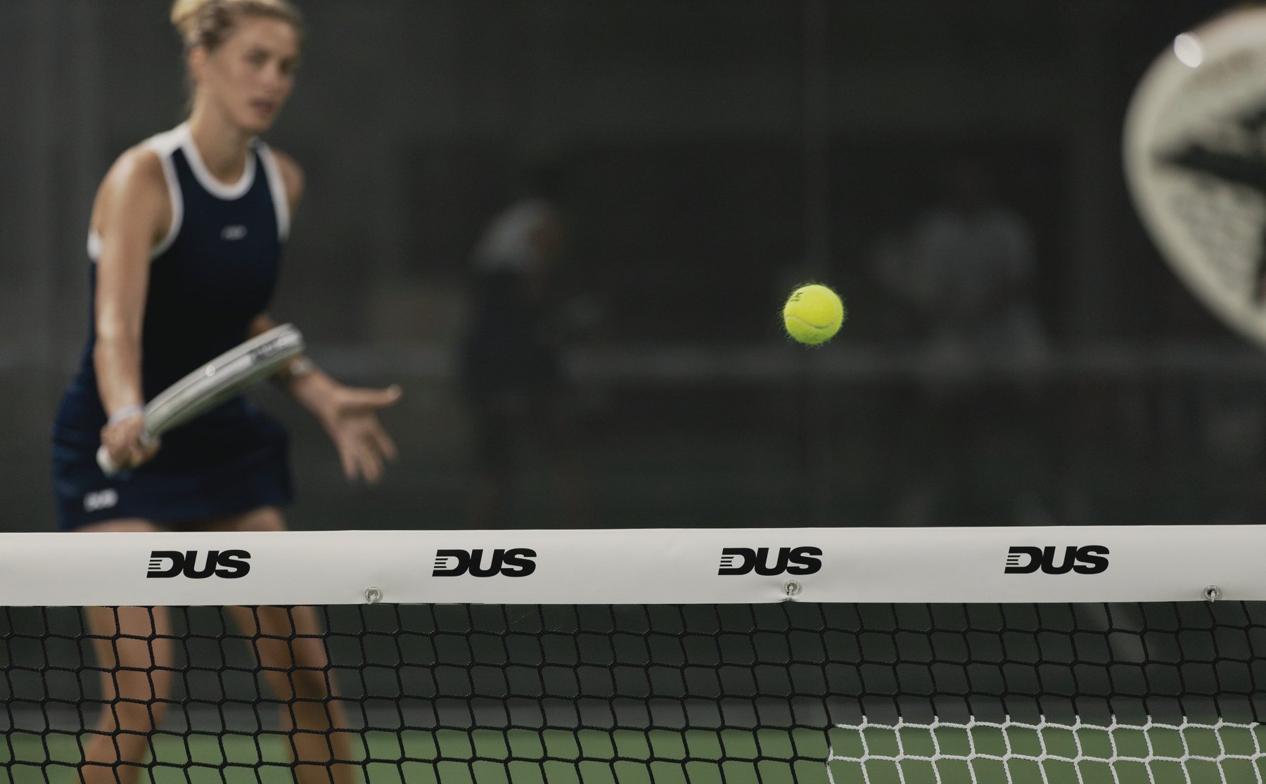 A player at the net on an indoor court at DUS West Palm Beach