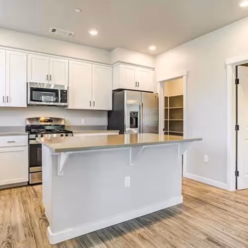 Kitchen with island, white cabinets, and stainless steel appliances