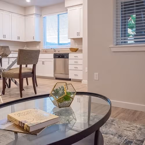 View from living area with coffee table into dining and kitchen area