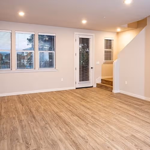 Unfurnished living area with wood flooring and large windows