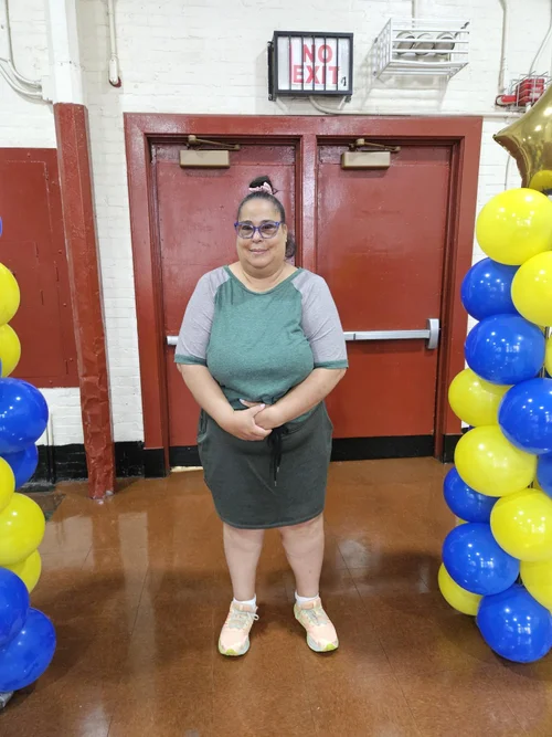 Parent coordinator standing between blue and yellow balloon columns