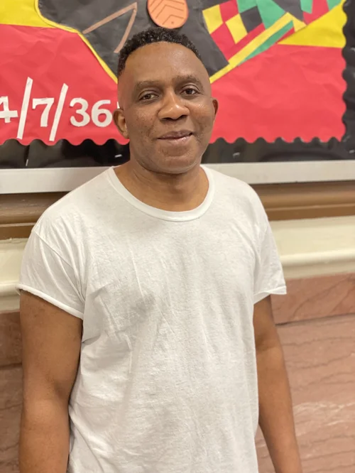 Male custodial staff member smiling in school hallway