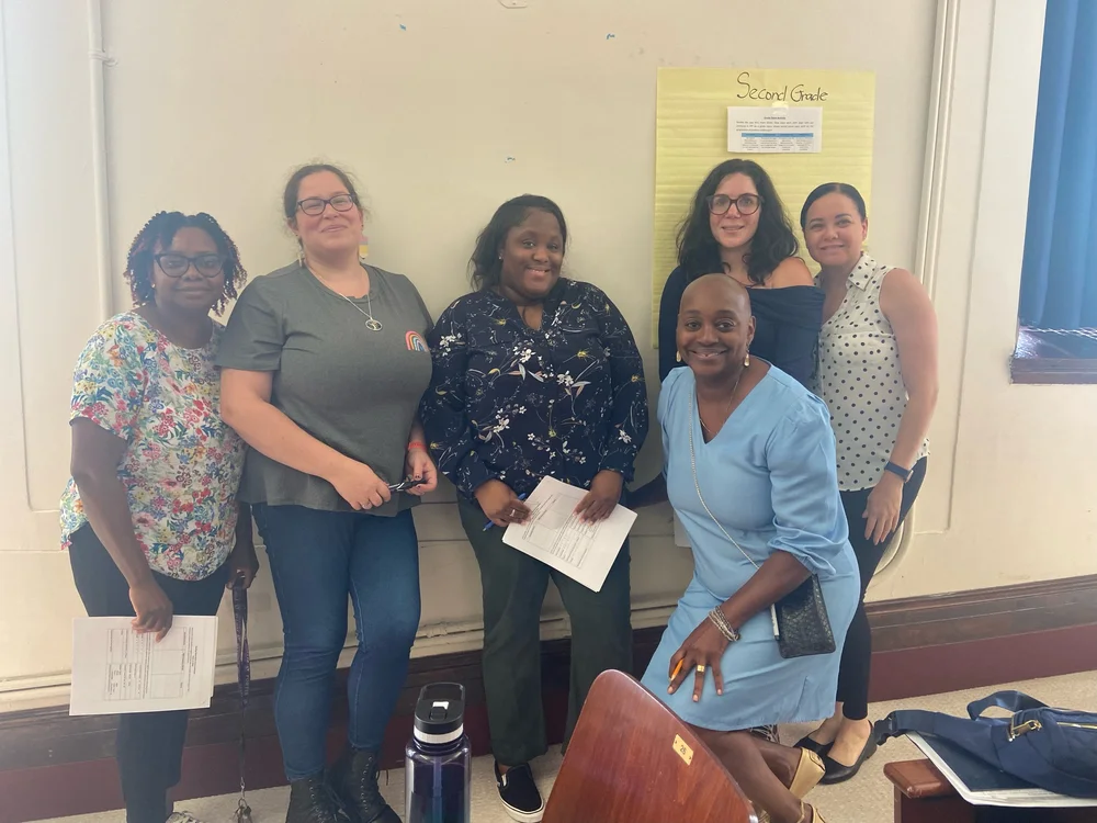 Six second grade staff members posing together in classroom