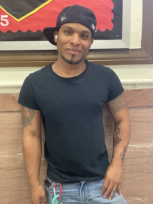 Male custodial staff member smiling outside school building
