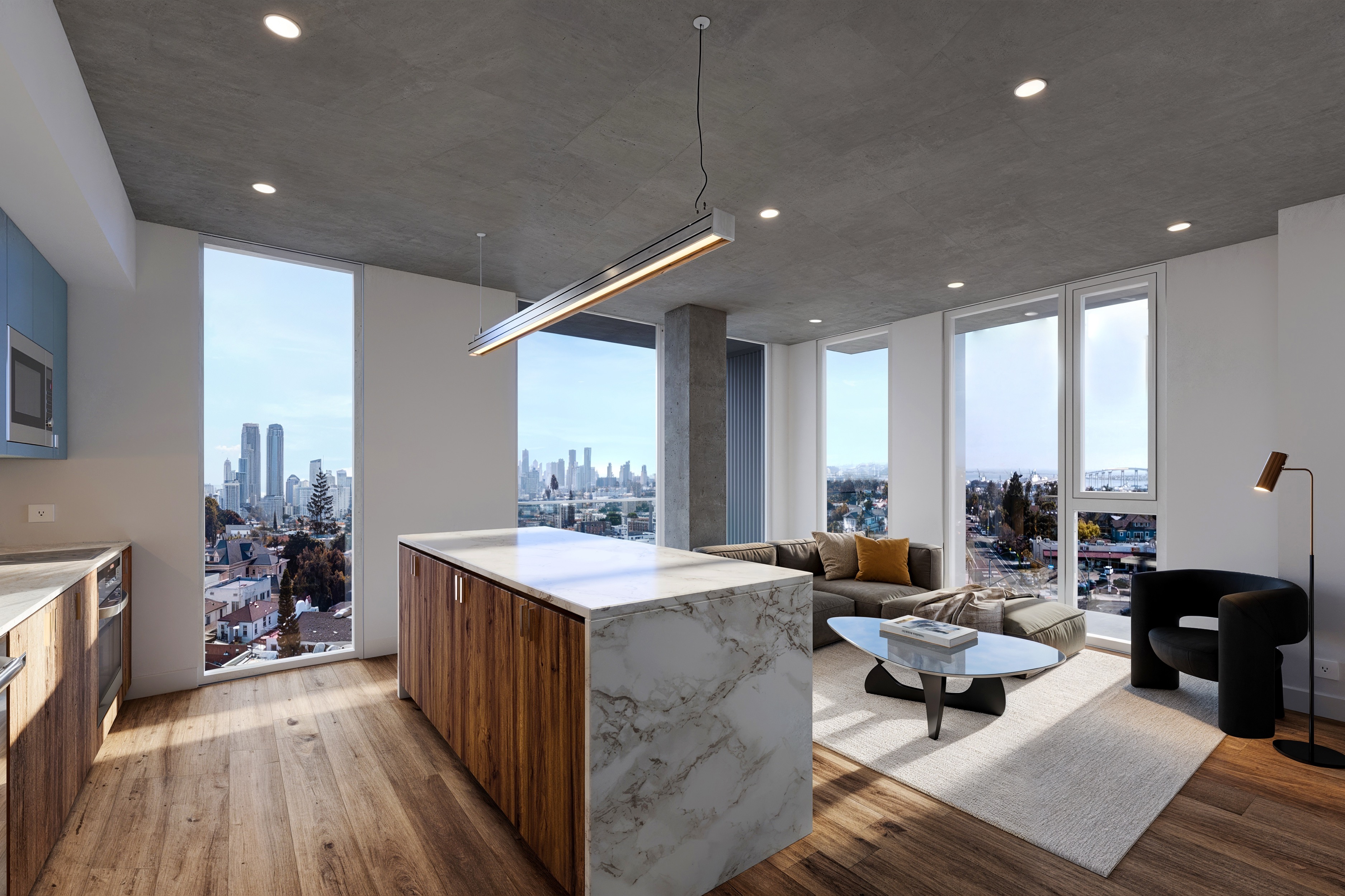 Modern apartment interior with wood and marble kitchen island, gray sectional sofa, black armchair, and large windows showing city skyline.