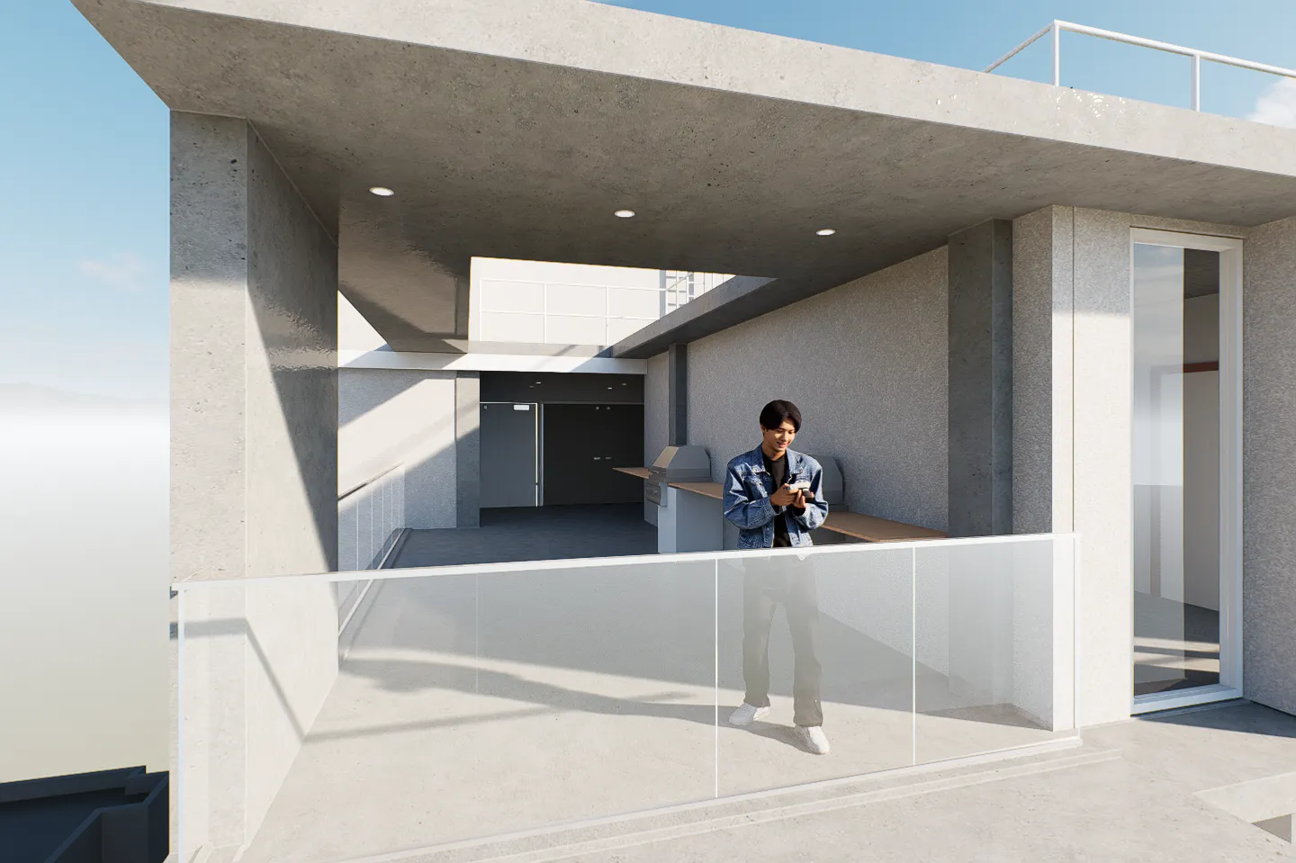 Young man in a denim jacket standing on a modern concrete balcony with glass railing, looking at his phone.