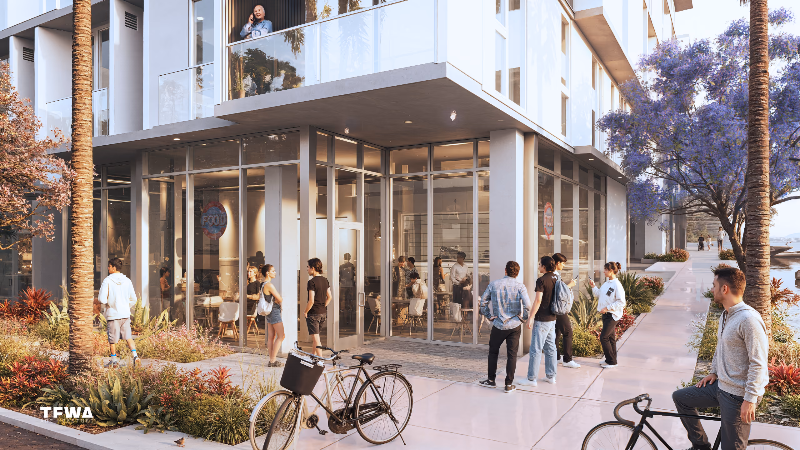 People gather outside a modern glass-front cafe with bicycles parked nearby and a person on a balcony above.