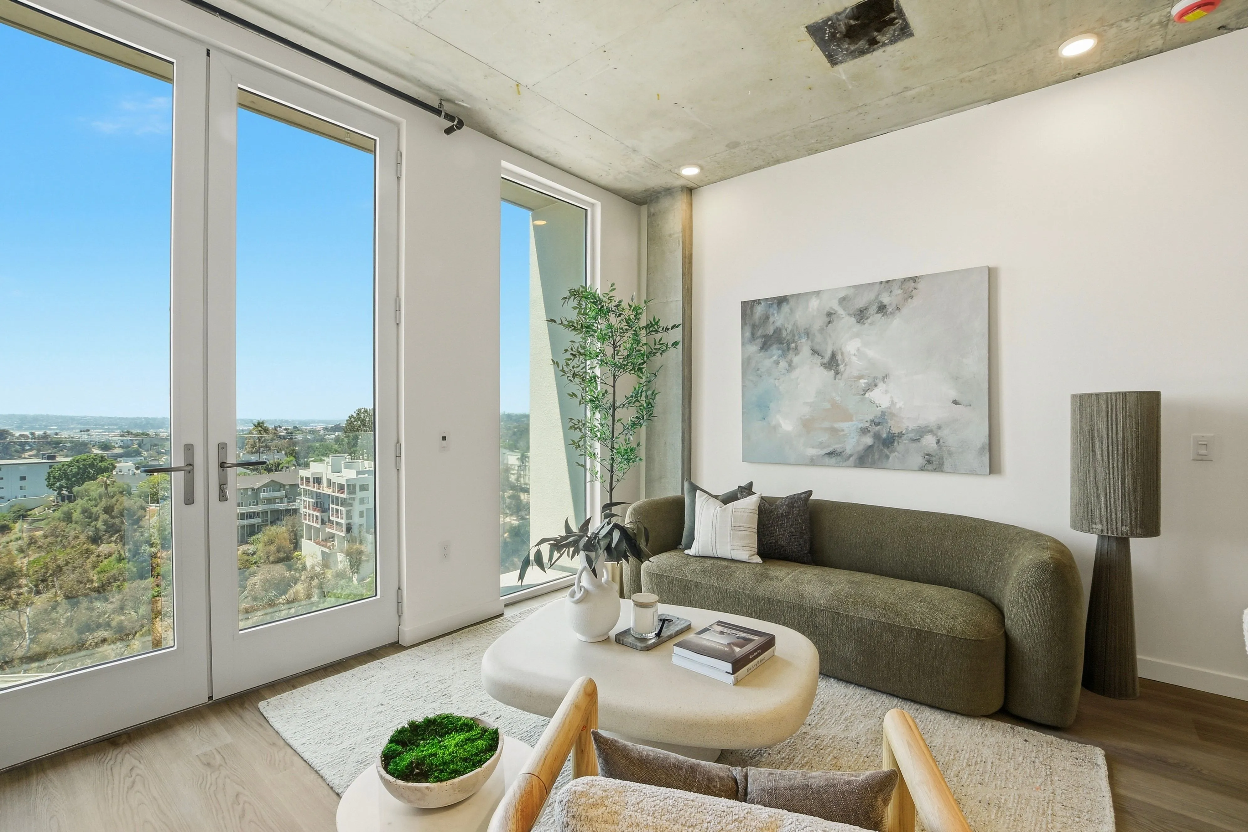 Bright Apollo apartment living room with floor-to-ceiling windows and city views