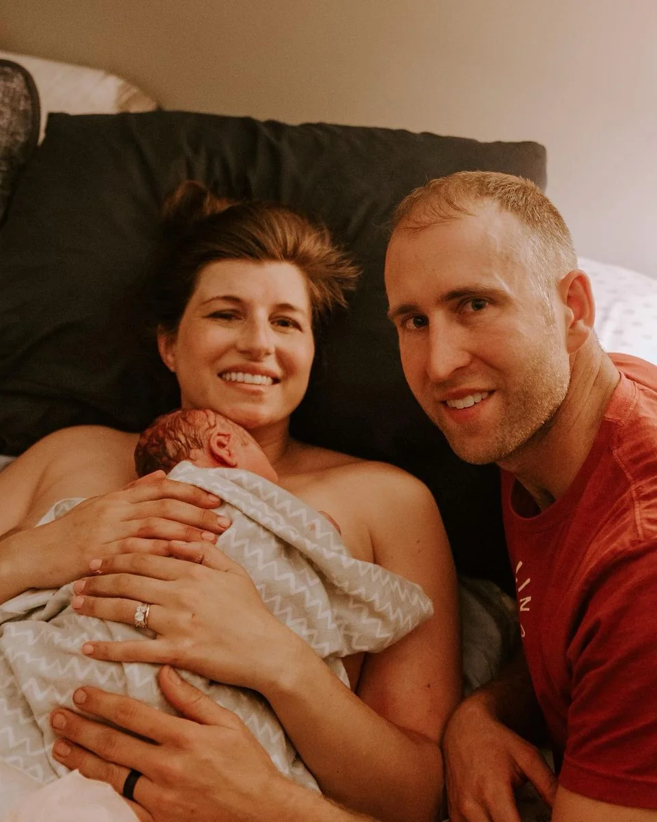 A woman with her newborn and partner