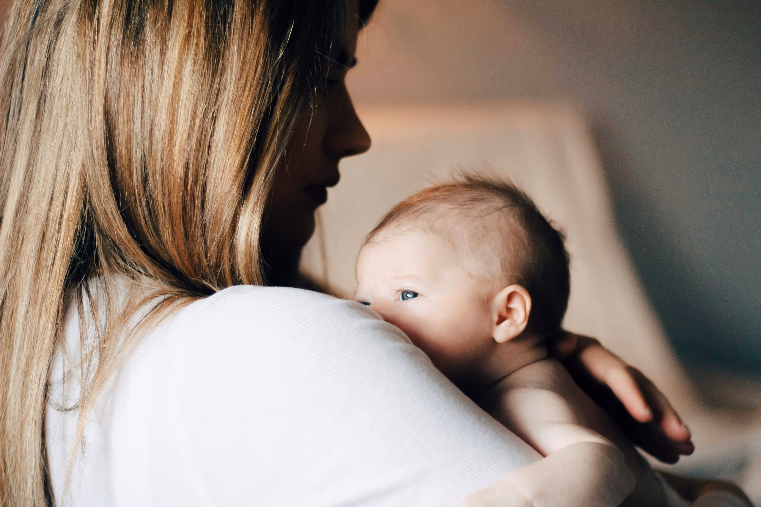 A mother holding her newborn to her shoulder