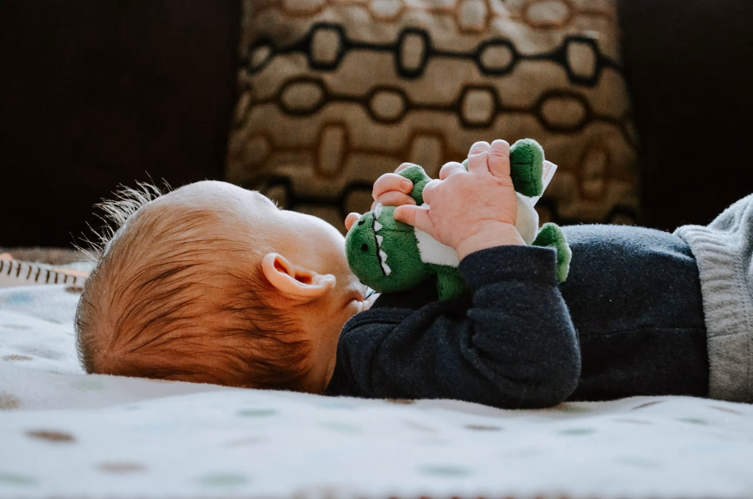 A baby with a stuffed animal toy.
