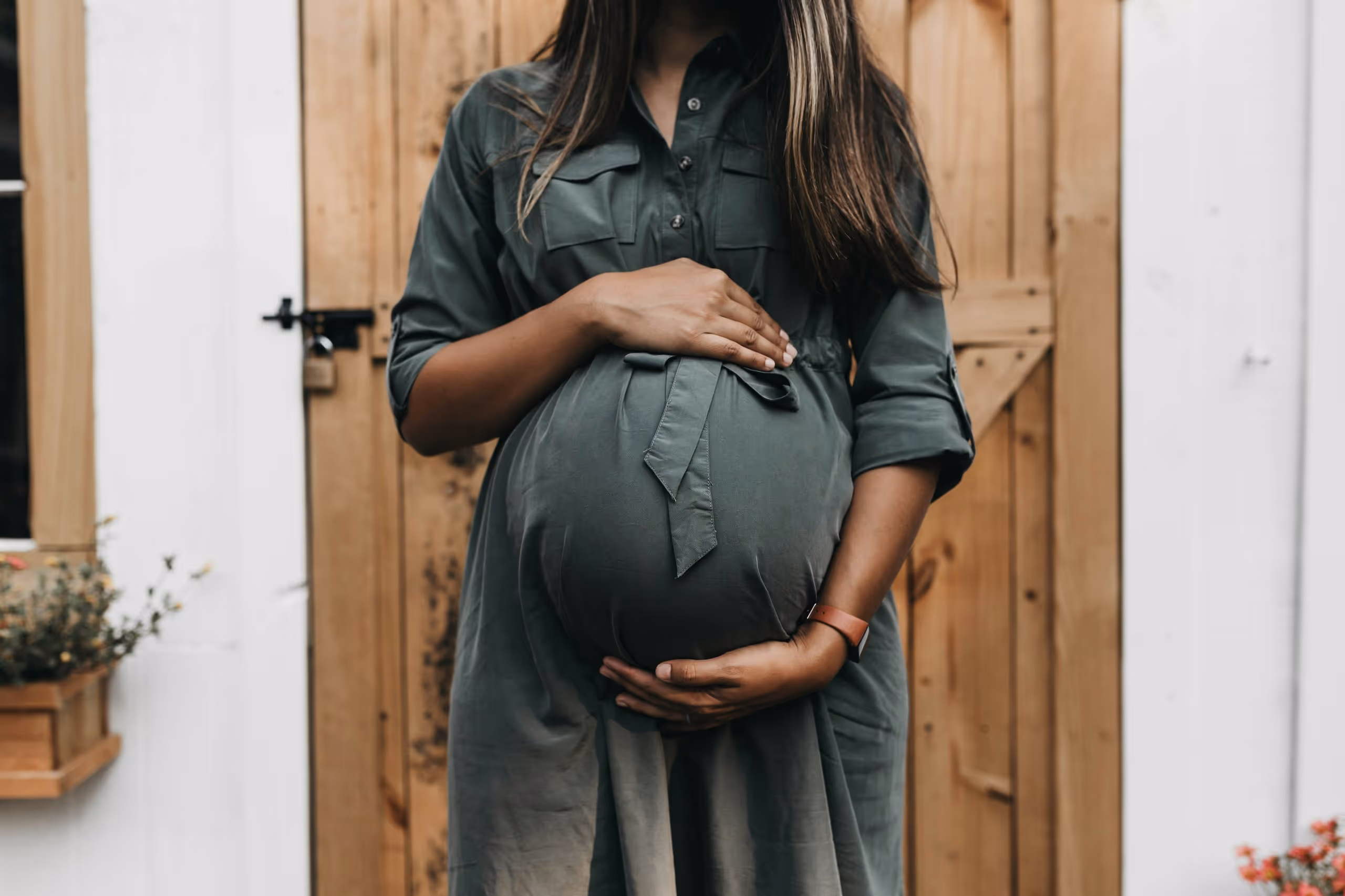 A pregnant woman touching her belly.