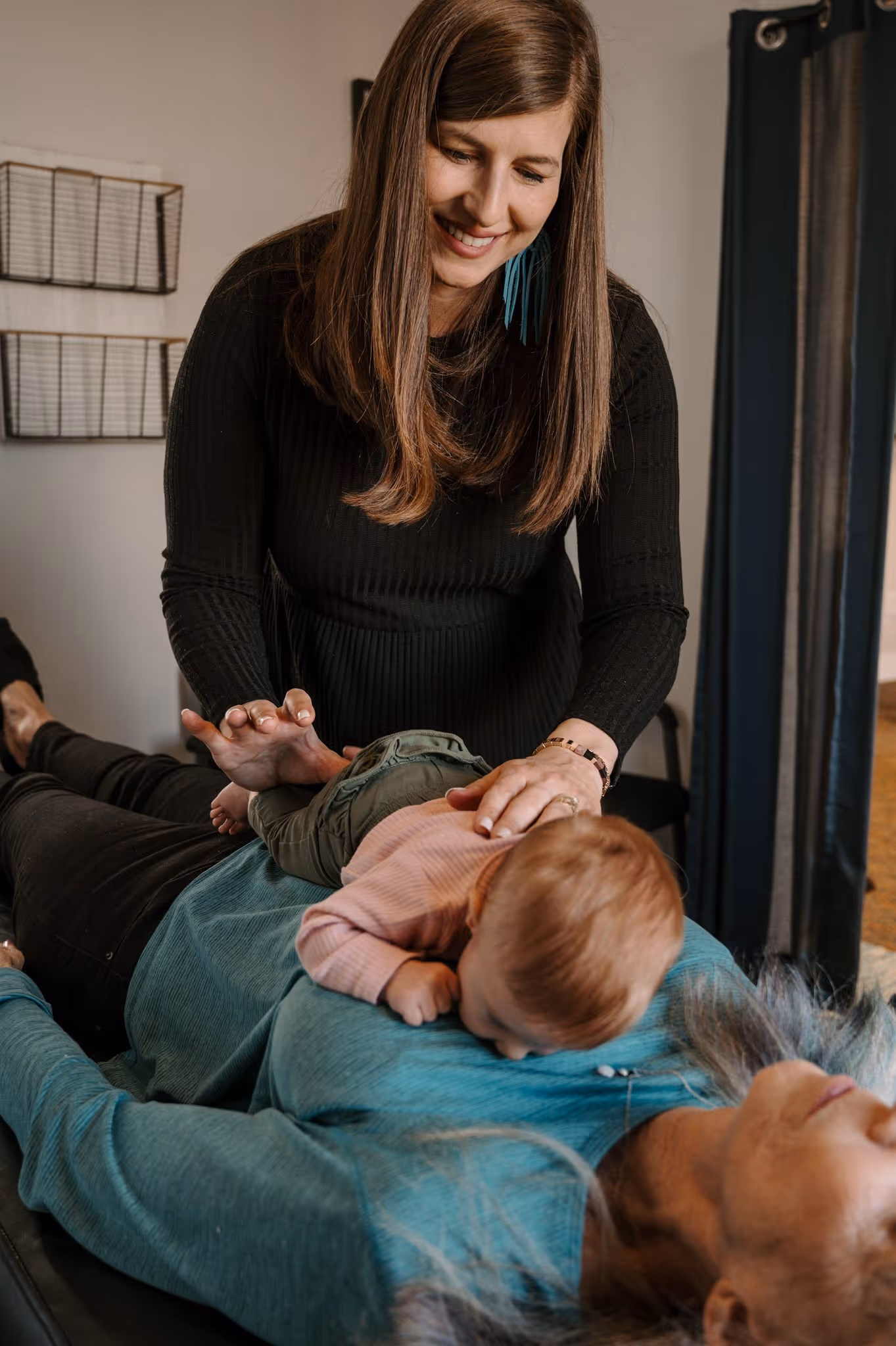 A baby receiving chiropractic care while resting with its mother.