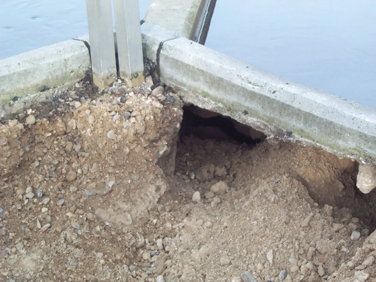 Hulrum langs skrå betonfelter som udgjorde bunden af rensningsanlægget