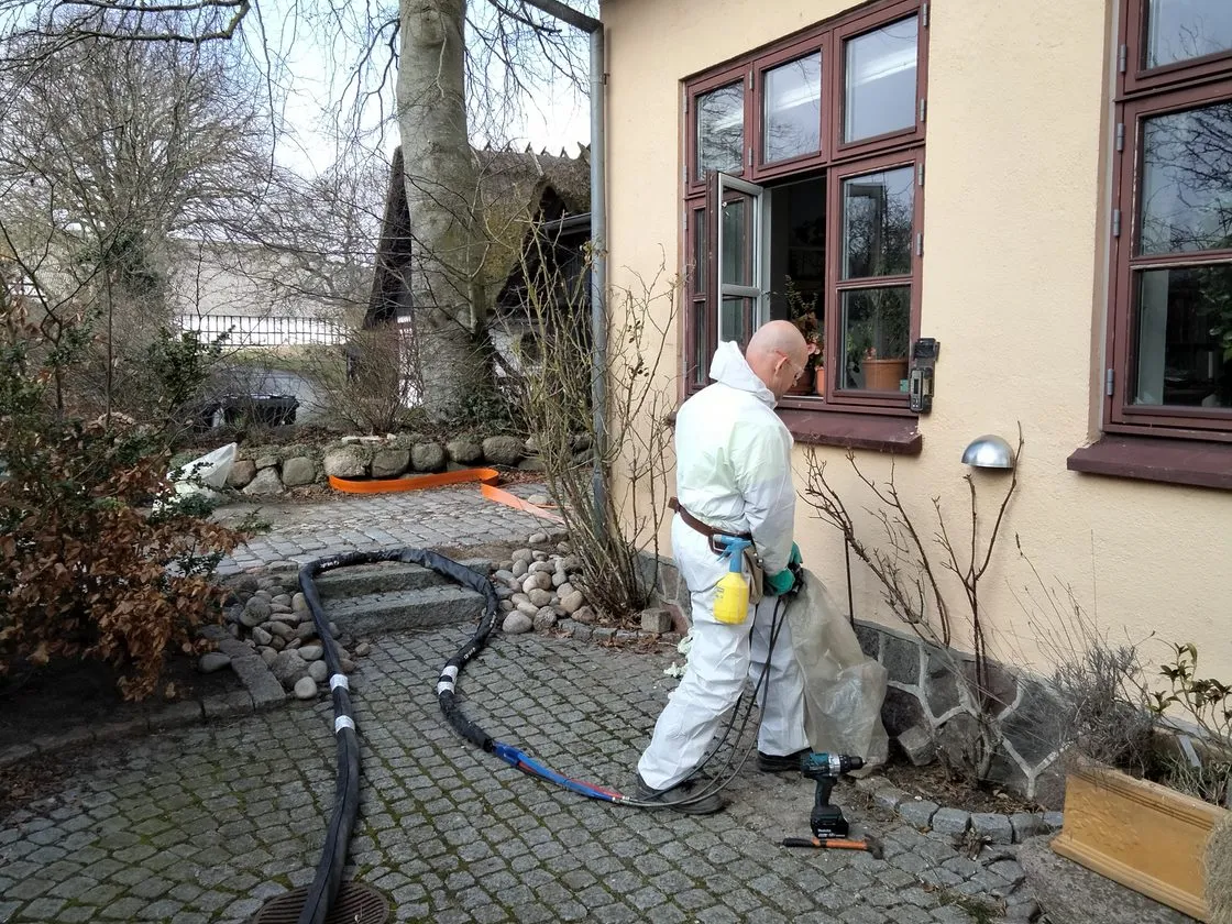 Ureteks montør injicerer materialet under ejendommens sydside