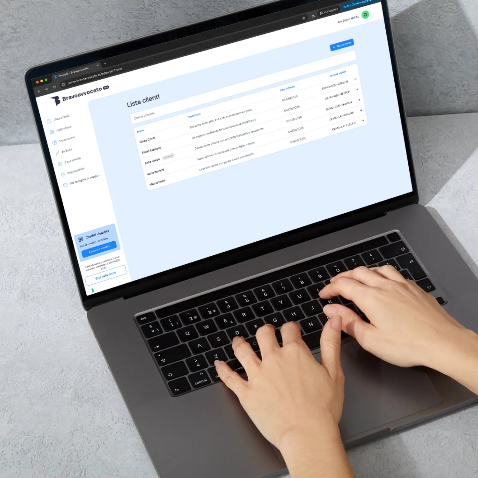 Mani che digitano su laptop con lista clienti visibile su software Bravoavvocato in italiano.