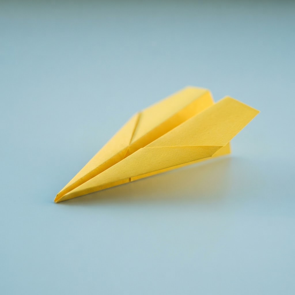 A yellow paper airplane on a light blue background