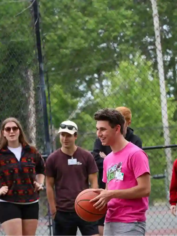 Cam counselor teaching skateboarding activity at AmeriCamp AU summer camp in USA for Australians.