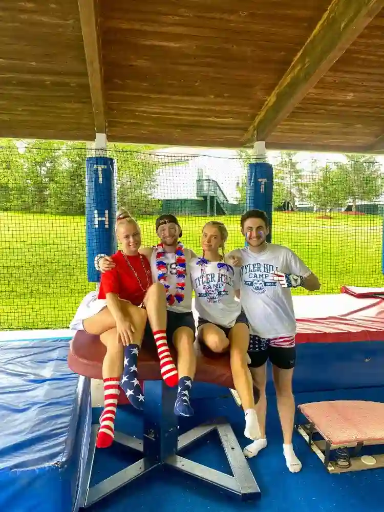 Camp counsellors coaching gymnastics at a USA summer camp.