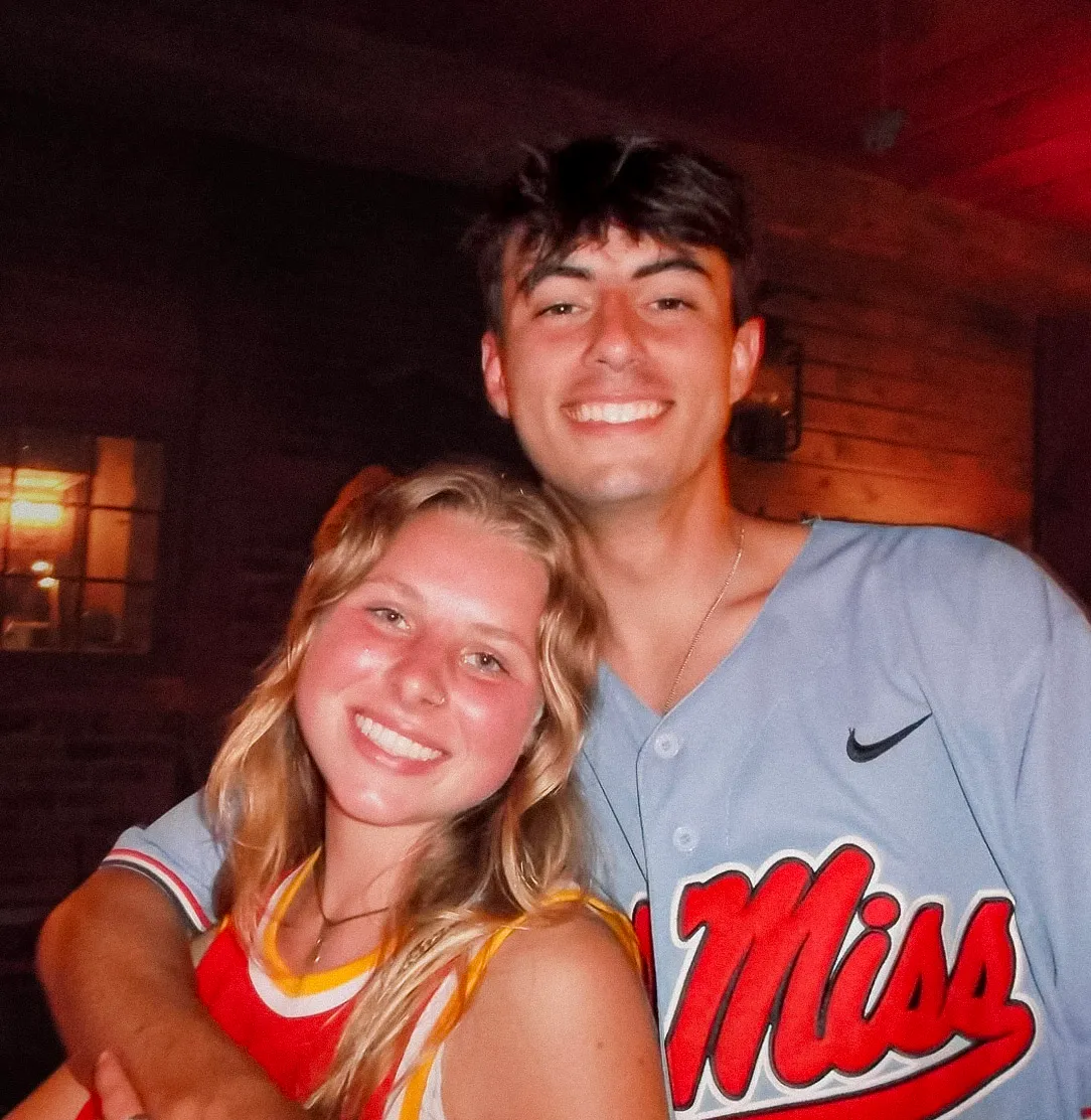 Two AmeriCamp summer camp friends smiling together during an evening social gathering in the USA.